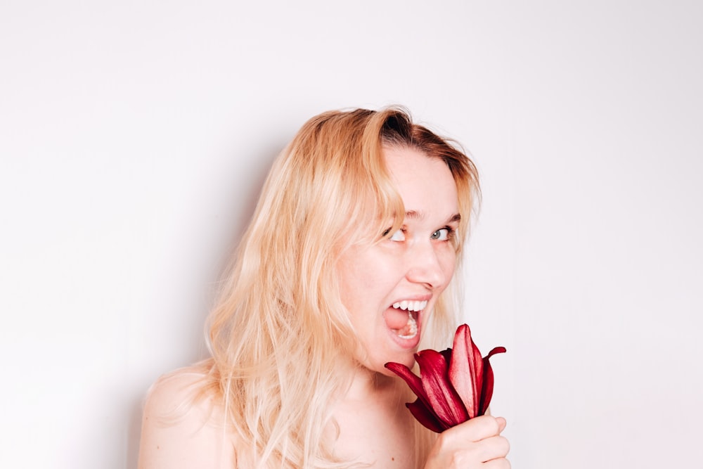 blonde woman holding red tulip