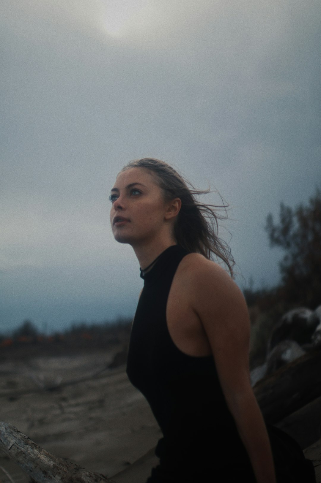 woman in black tank top standing on brown field during daytime