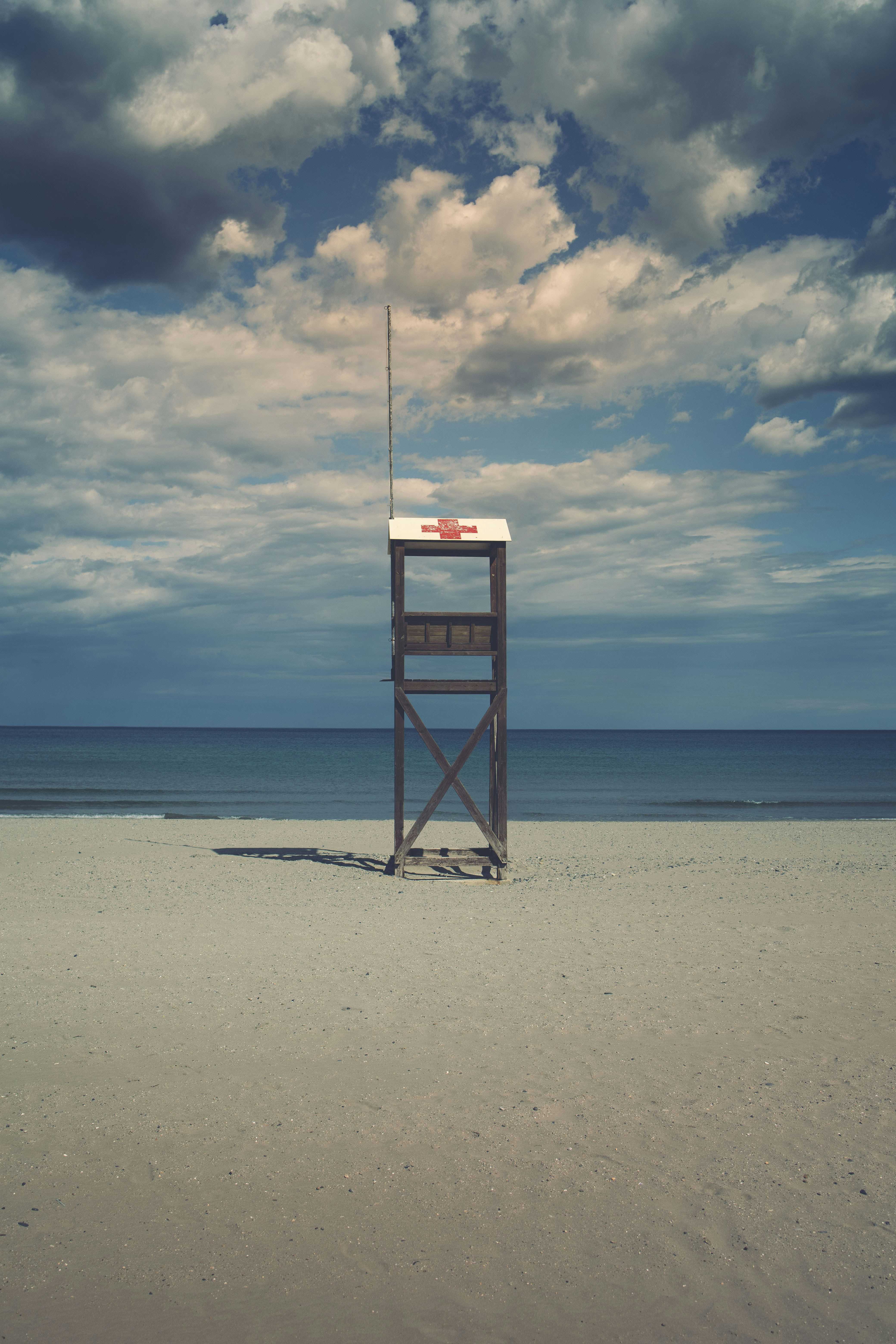 black wooden lifeguard tower on beach during daytime