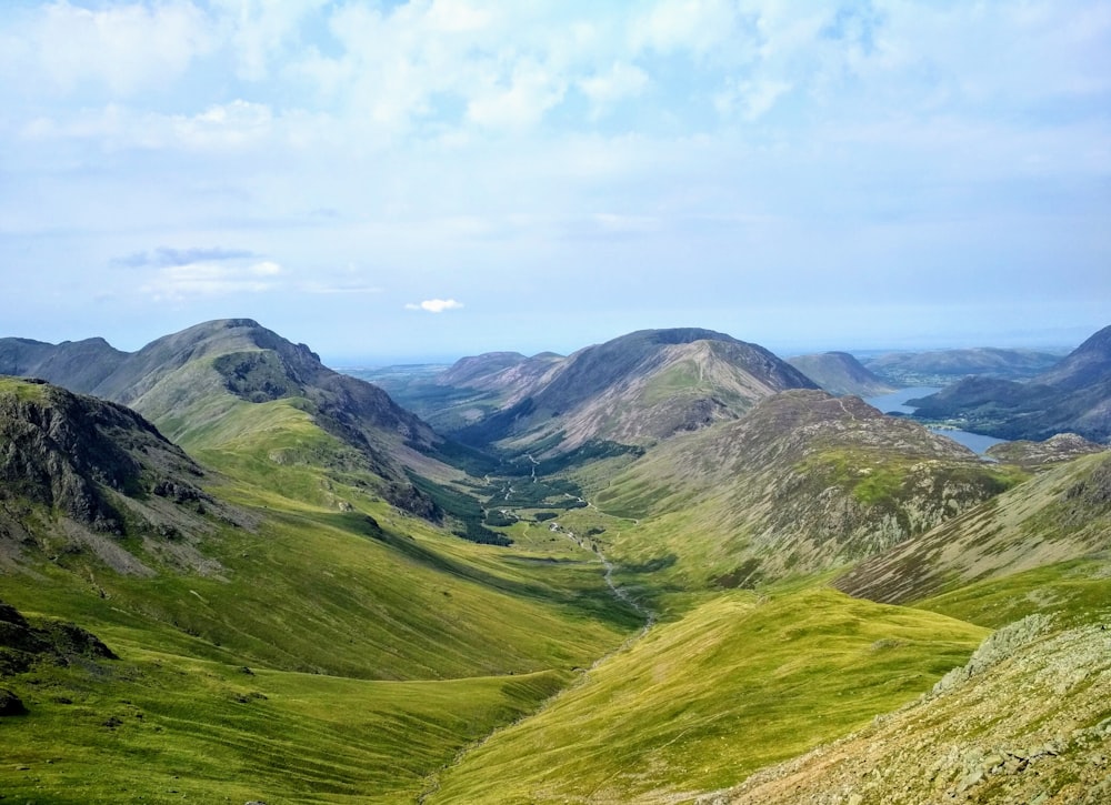 Grüne Berge tagsüber unter weißen Wolken