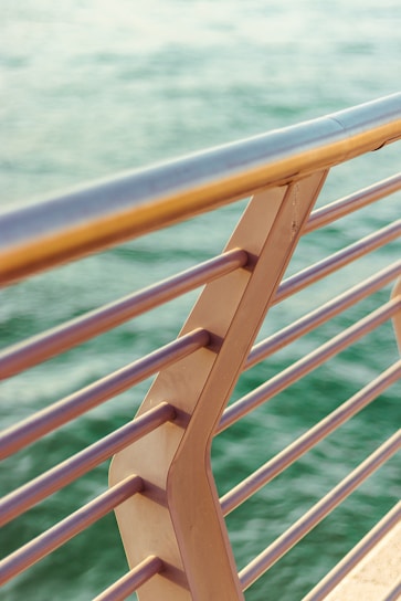 brown wooden railings near body of water during daytime