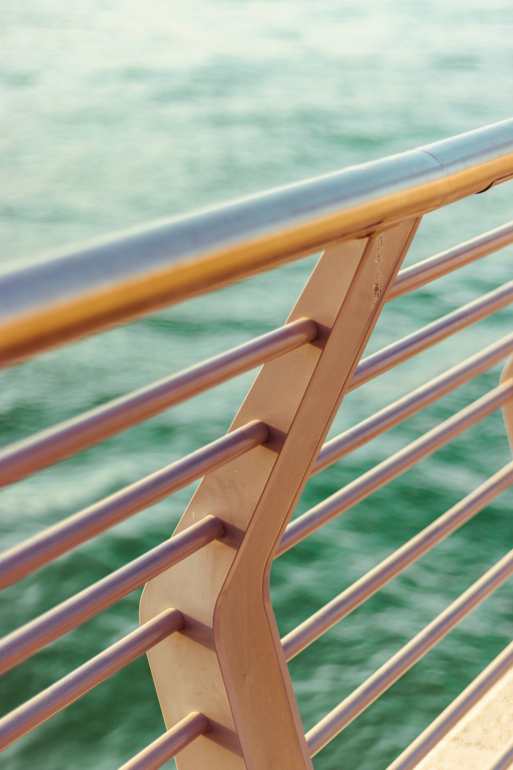brown wooden railings near body of water during daytime