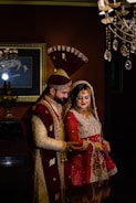 A groom wearing a traditional sherwani with detailed zari work, smiling confidently.