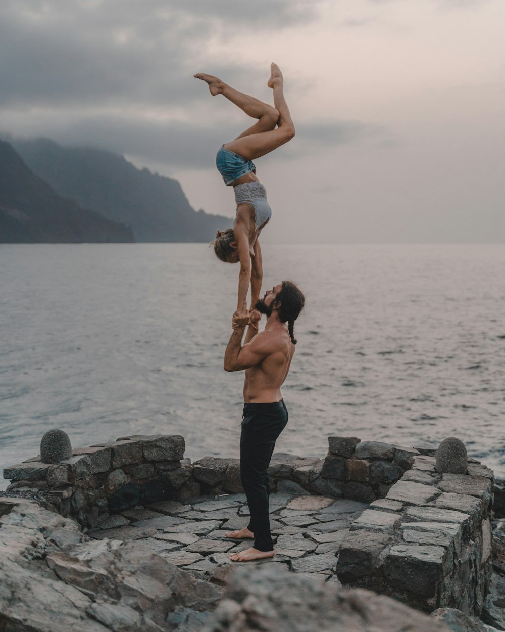 a man doing a handstand with a woman on his back