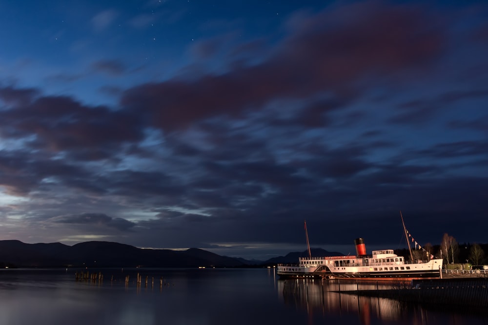 white and brown ship on sea under gray clouds