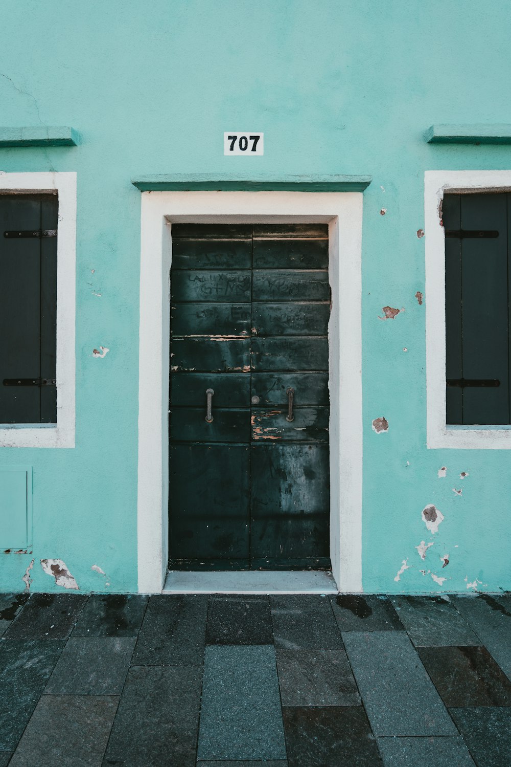 white wooden door with green concrete wall