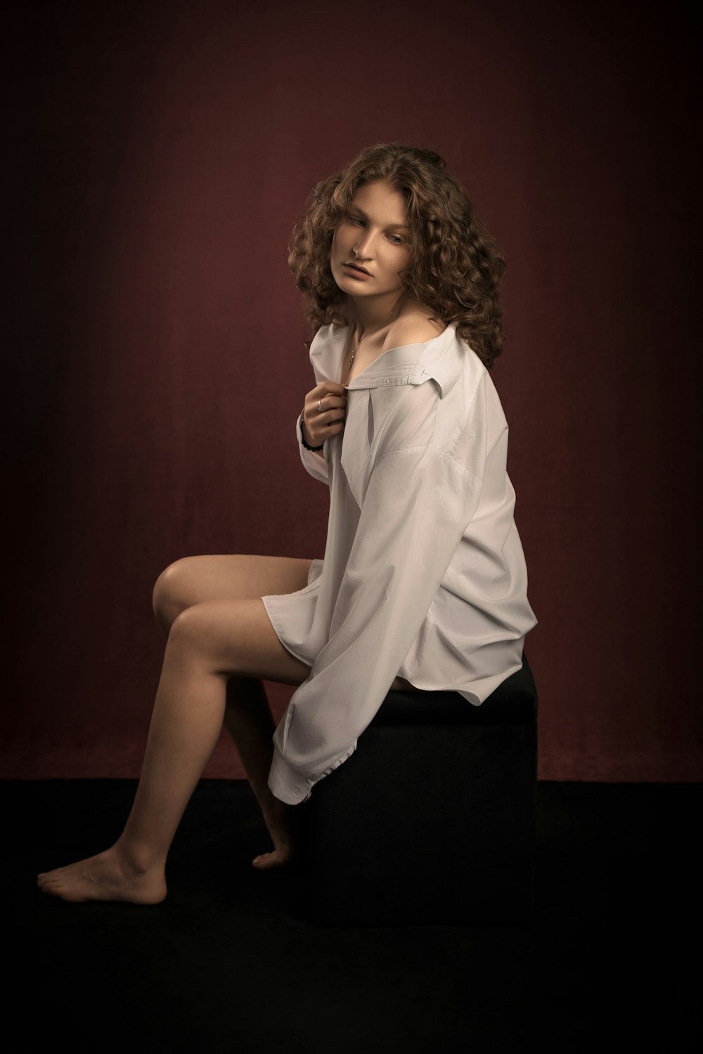 woman in white dress shirt and black skirt sitting on black chair