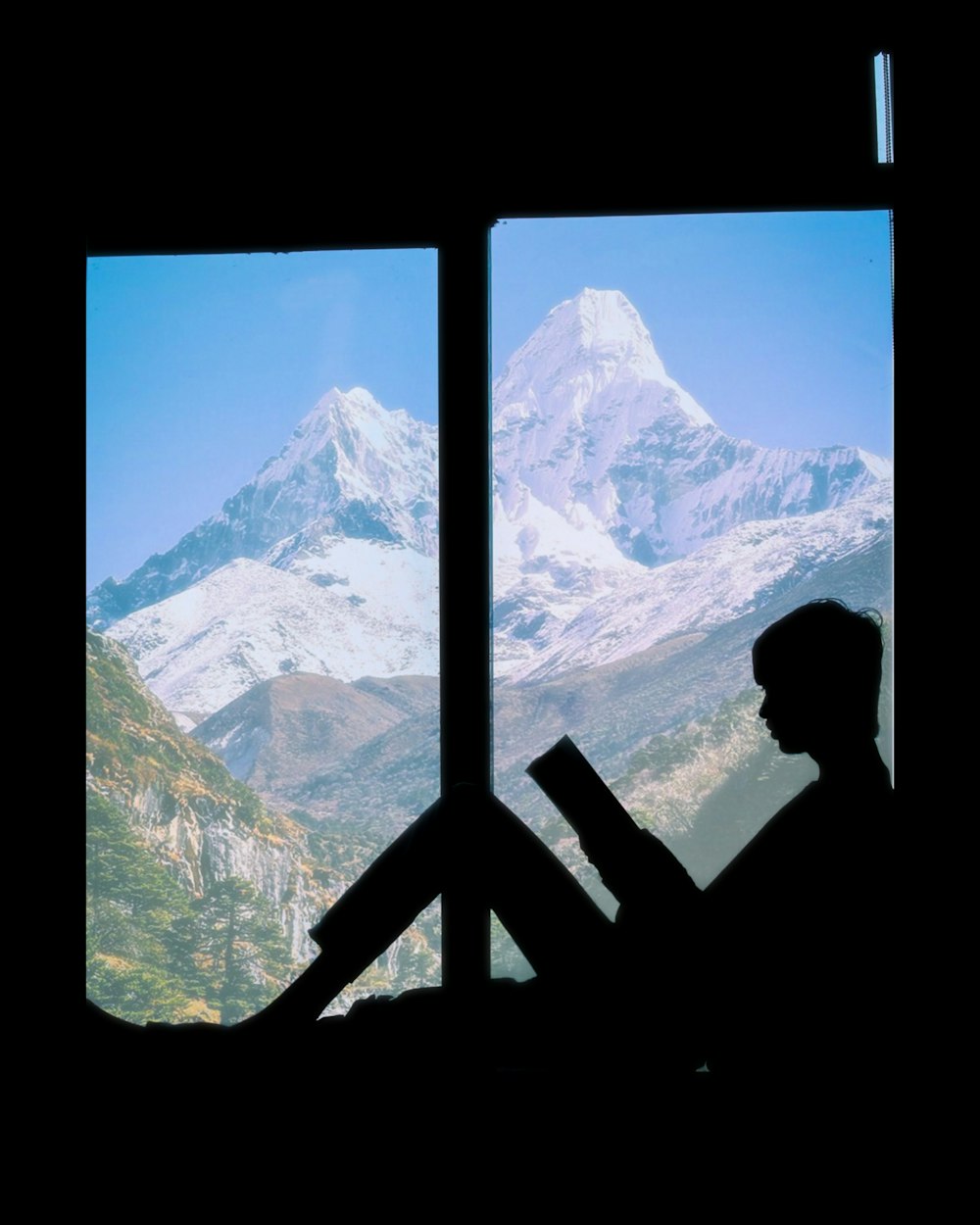 silhouette of man standing on window looking at snow covered mountains during daytime