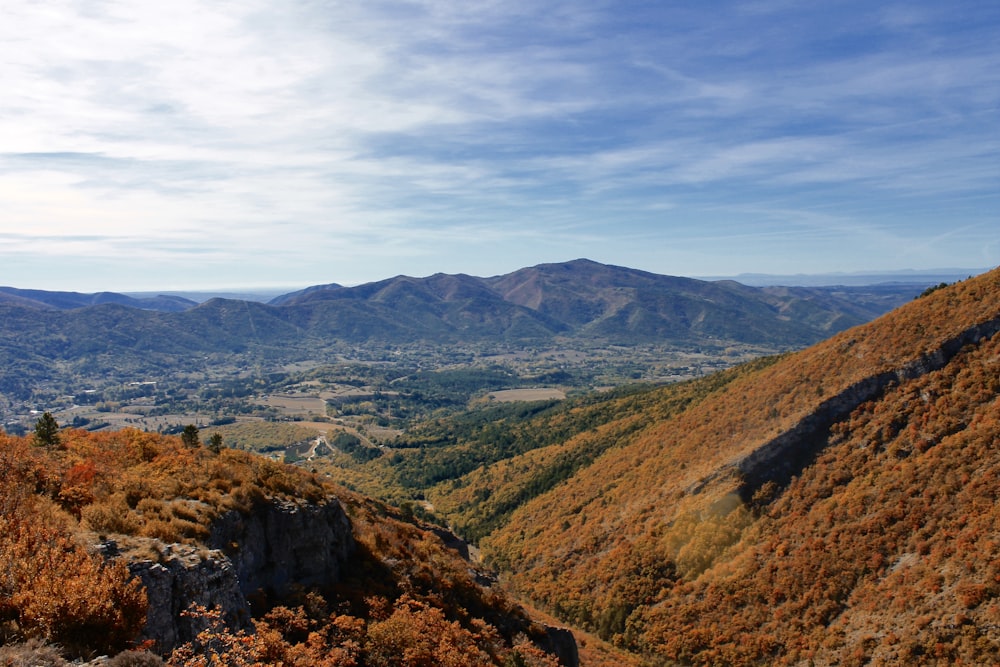 montanhas verdes e marrons sob nuvens brancas durante o dia