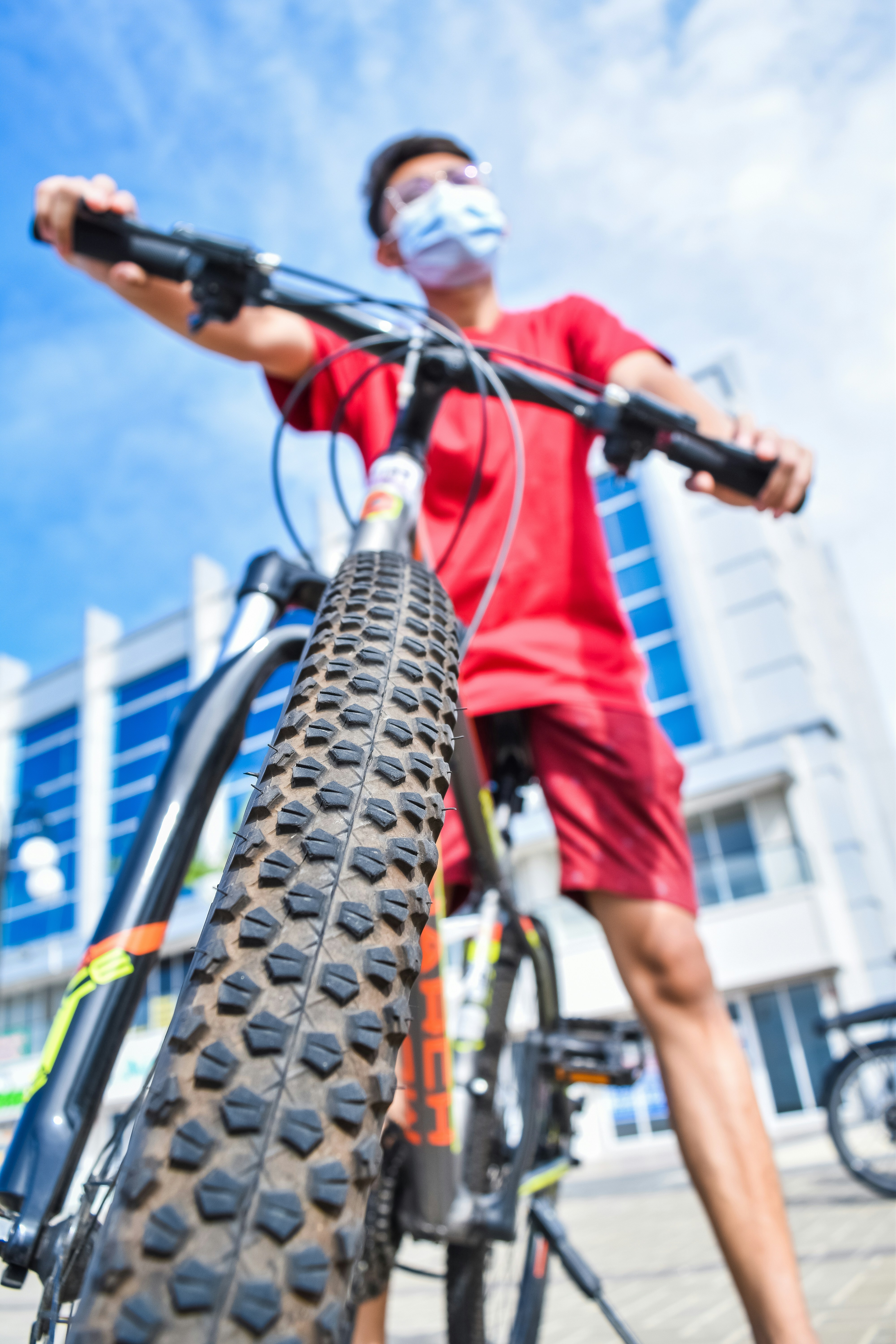 man in red shirt riding bicycle during daytime
