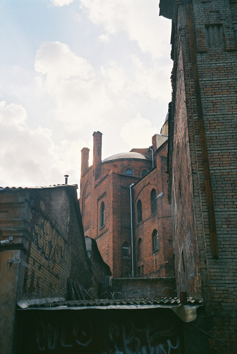 brown brick building under white clouds during daytime