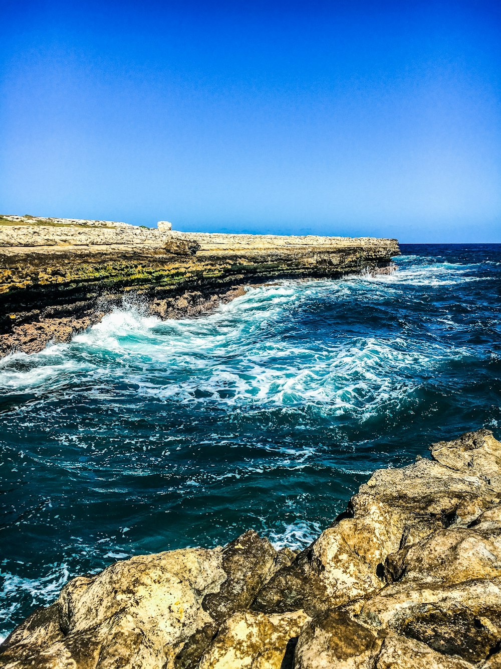 brown rocky shore under blue sky during daytime