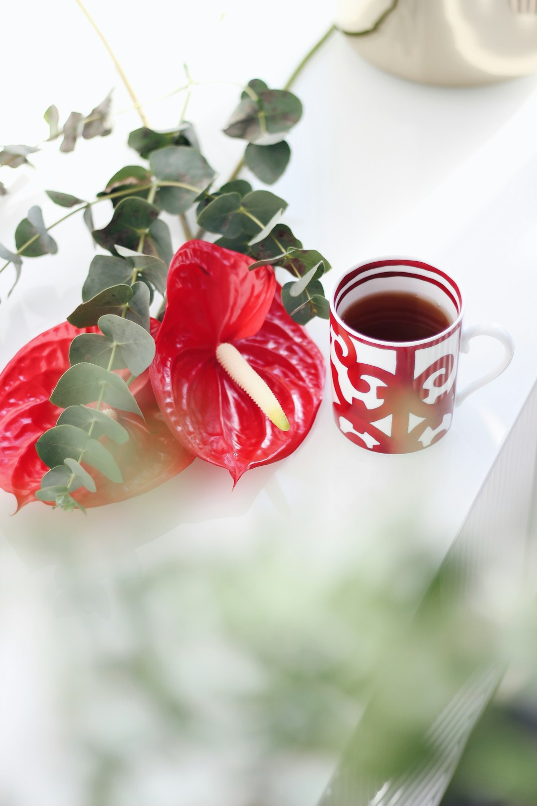 red roses beside white and red ceramic mug