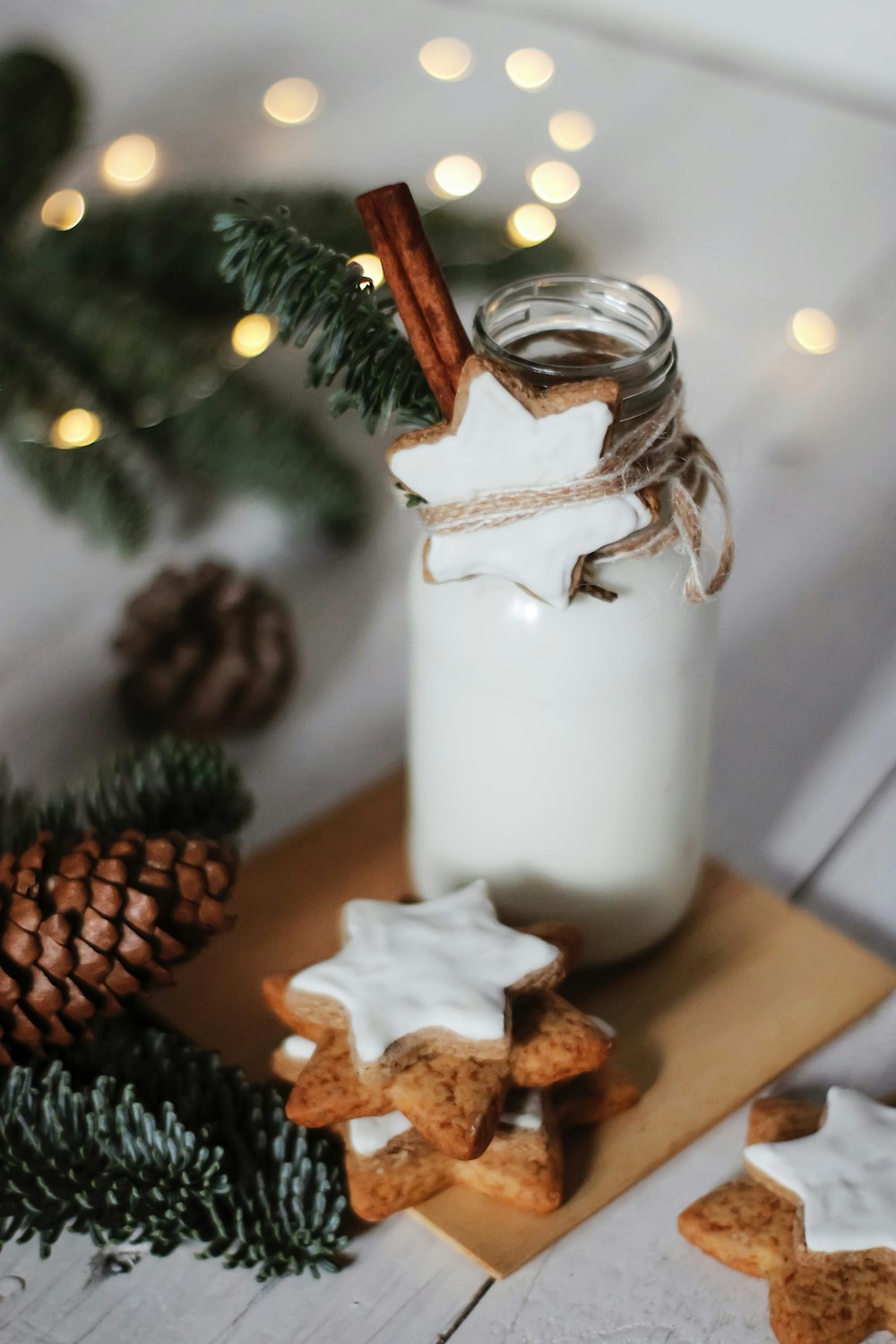 white pillar candle beside brown pine cone