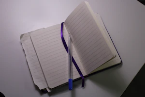 An open notebook with colorful templates and a pen beside it.