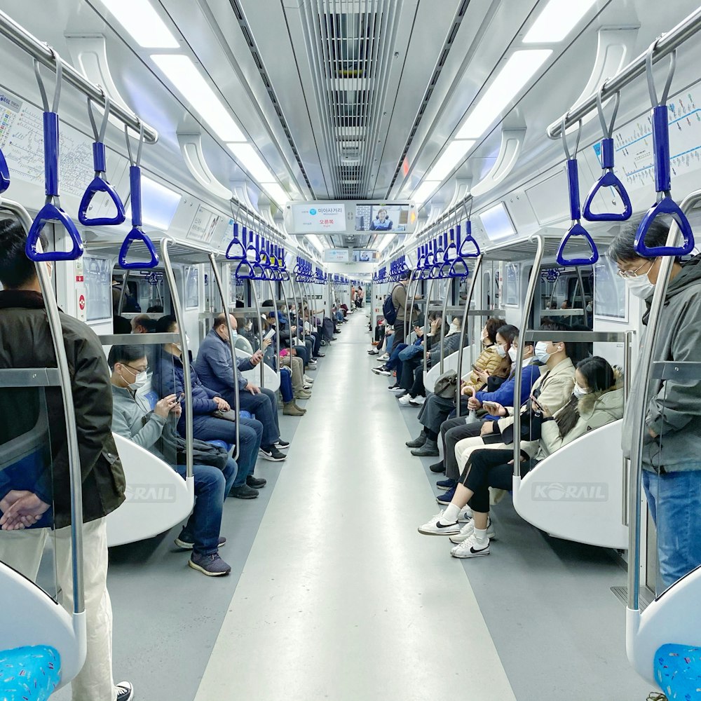 파란색과 흰색 버스 좌석에 앉아있는 사람들