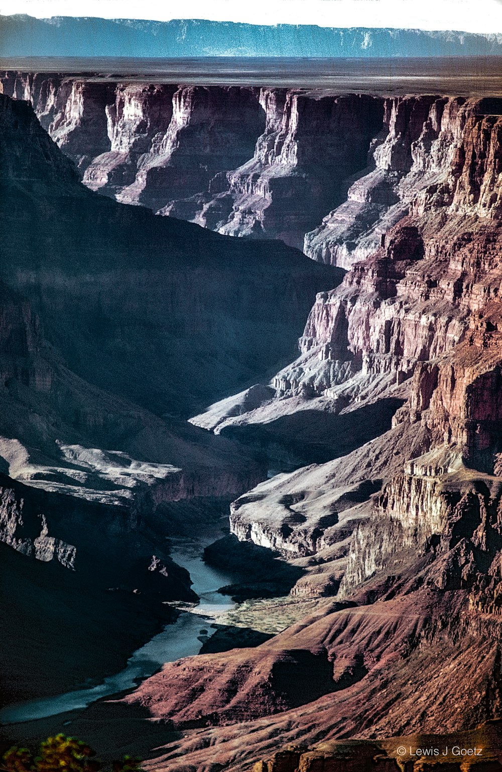 brown rocky mountain beside body of water during daytime