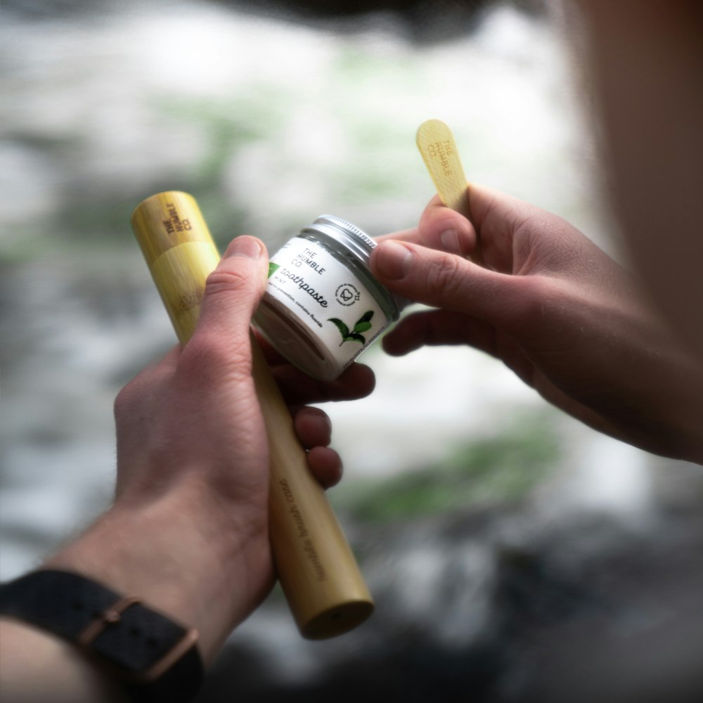 person holding white and green labeled can