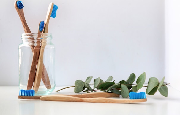 blue and white toothbrush in clear glass jar