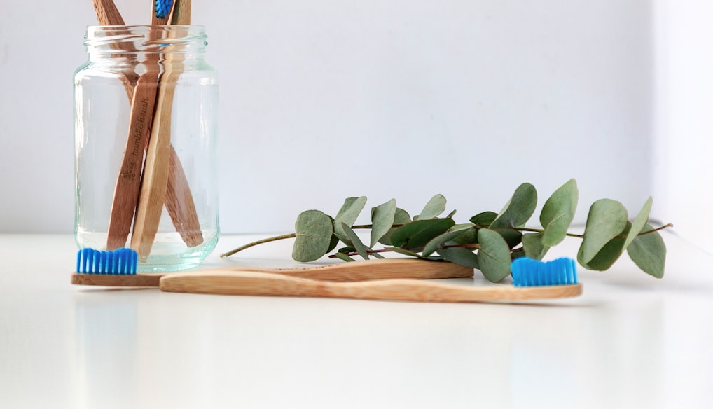 blue and white toothbrush in clear glass jar