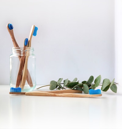 blue and white toothbrush in clear glass jar