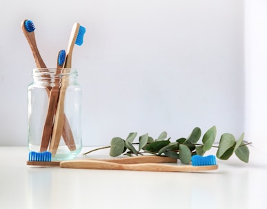 blue and white toothbrush in clear glass jar