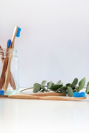 blue and white toothbrush in clear glass jar