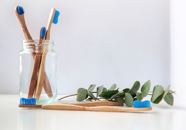 blue and white toothbrush in clear glass jar