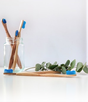 blue and white toothbrush in clear glass jar