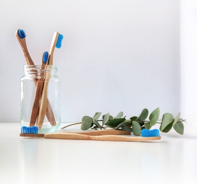 blue and white toothbrush in clear glass jar