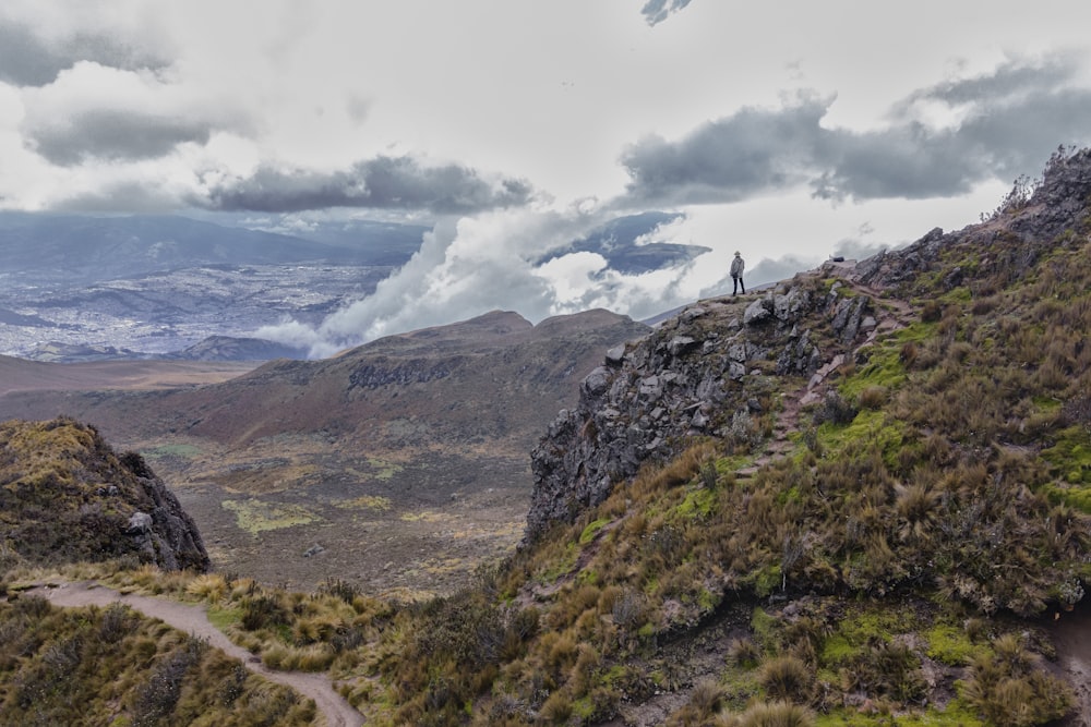 campo de hierba verde cerca del cuerpo de agua bajo nubes blancas durante el día