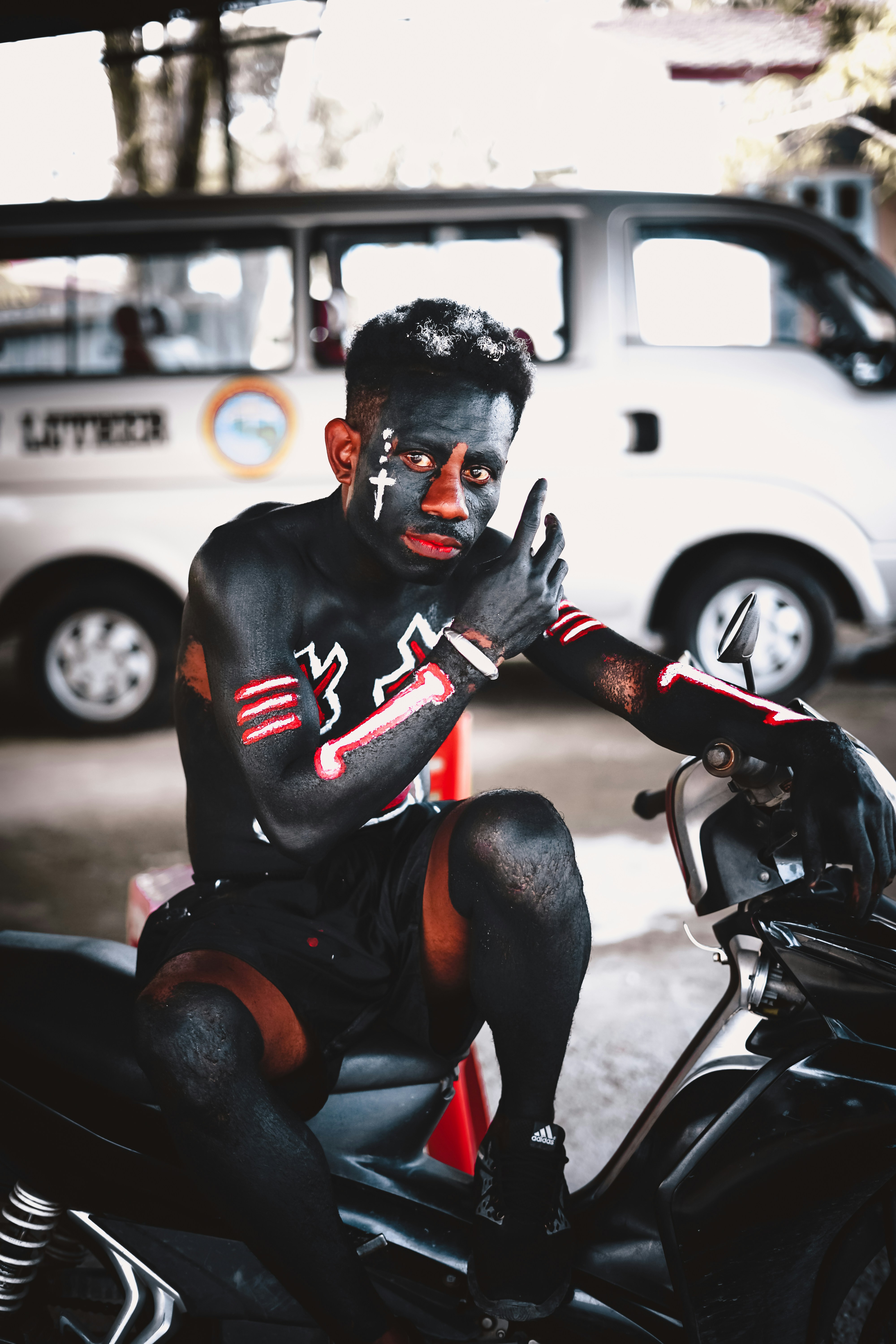 Mann in schwarzer und roter Maske auf schwarzem Motorrad