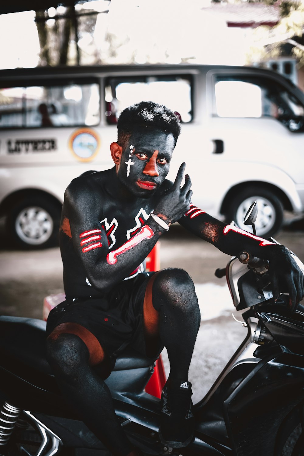 Mann in schwarzer und roter Maske auf schwarzem Motorrad