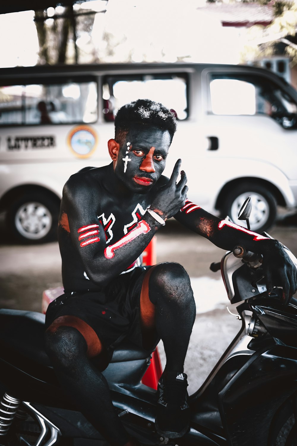 man in black and red mask riding on black motorcycle