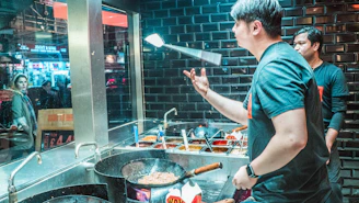 Chef Siobhan demonstrating a cooking technique to a small group in a bright kitchen.