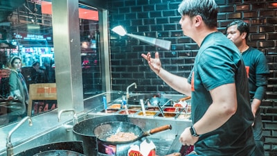 A chef tossing pizza dough skillfully in a cozy restaurant kitchen.