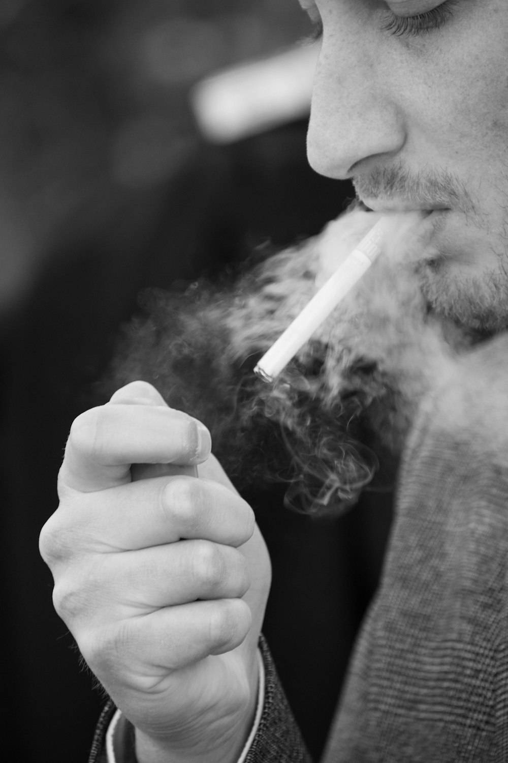 Foto en escala de grises de un hombre fumando