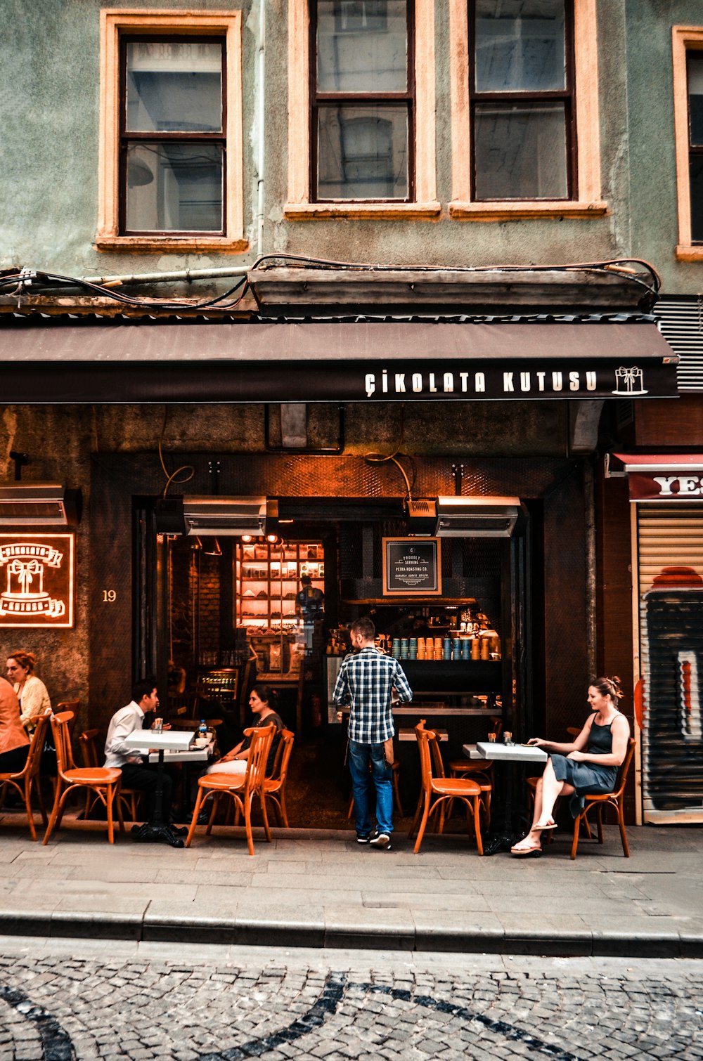 a group of people sitting at a table outside of a restaurant