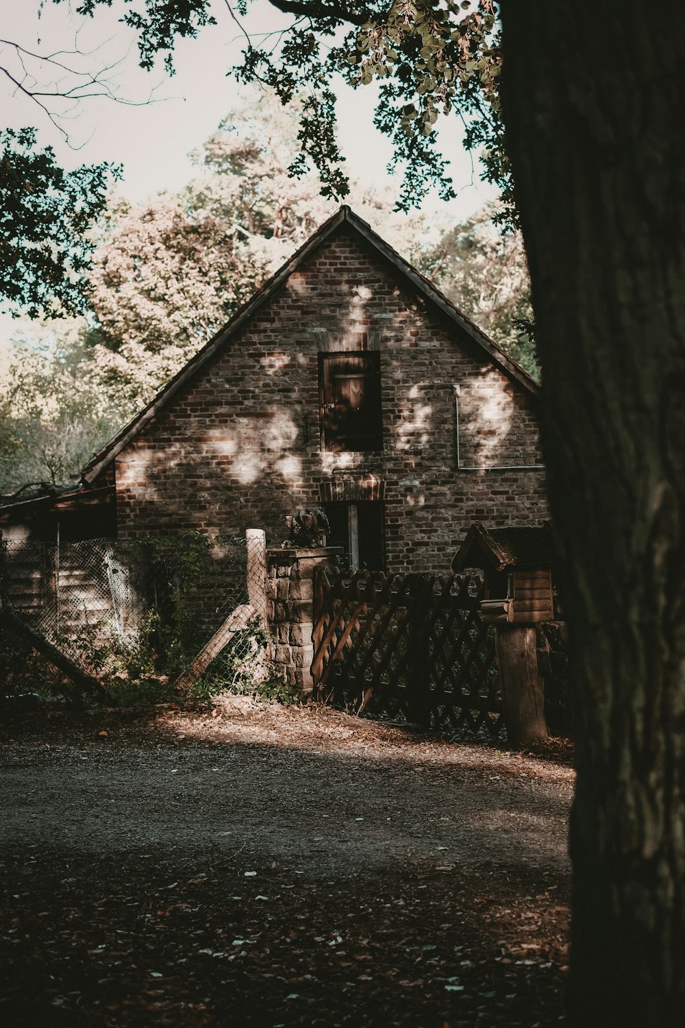 an old brick house with a tree in front of it