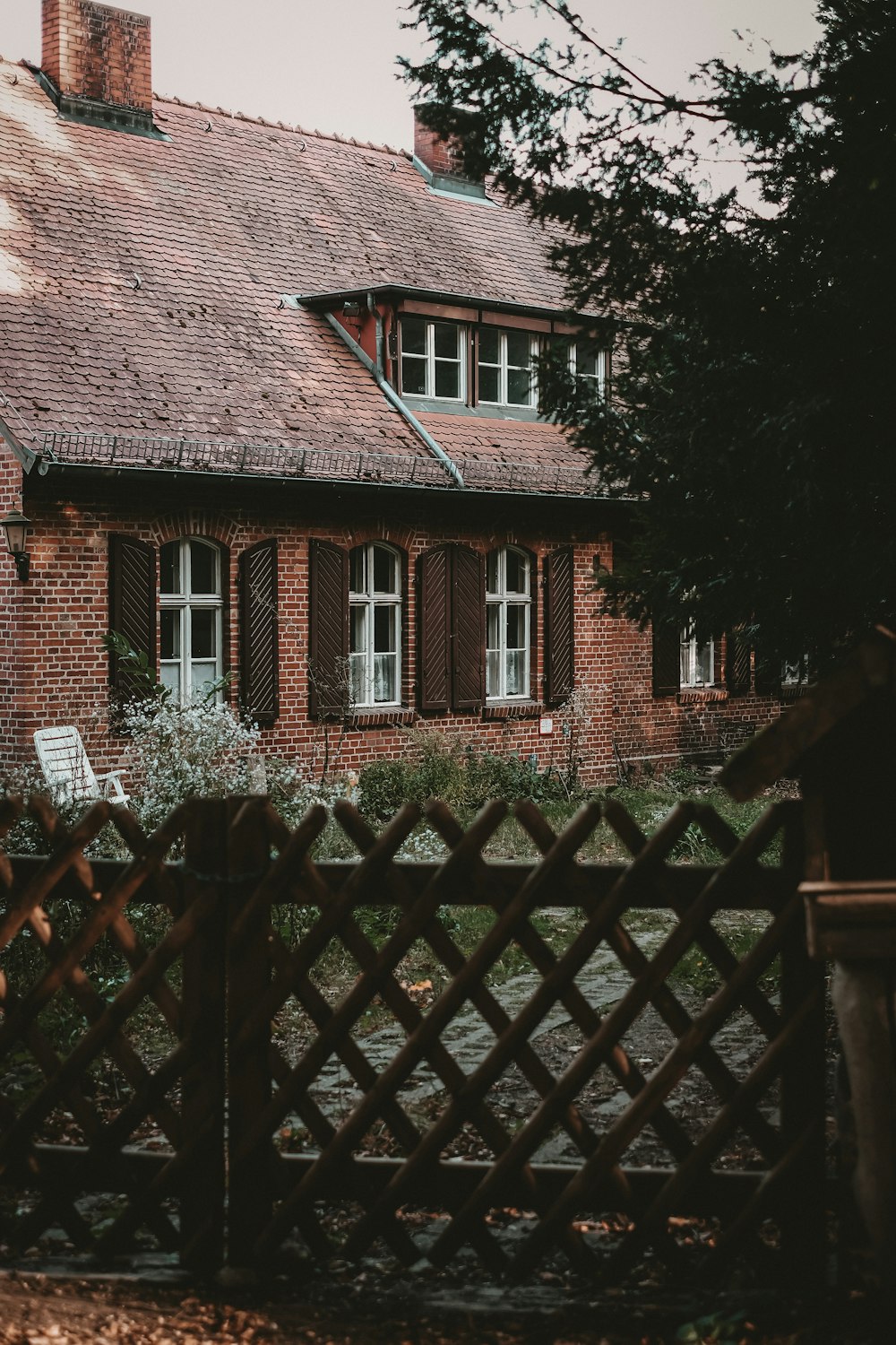 a brick house with a wooden fence in front of it