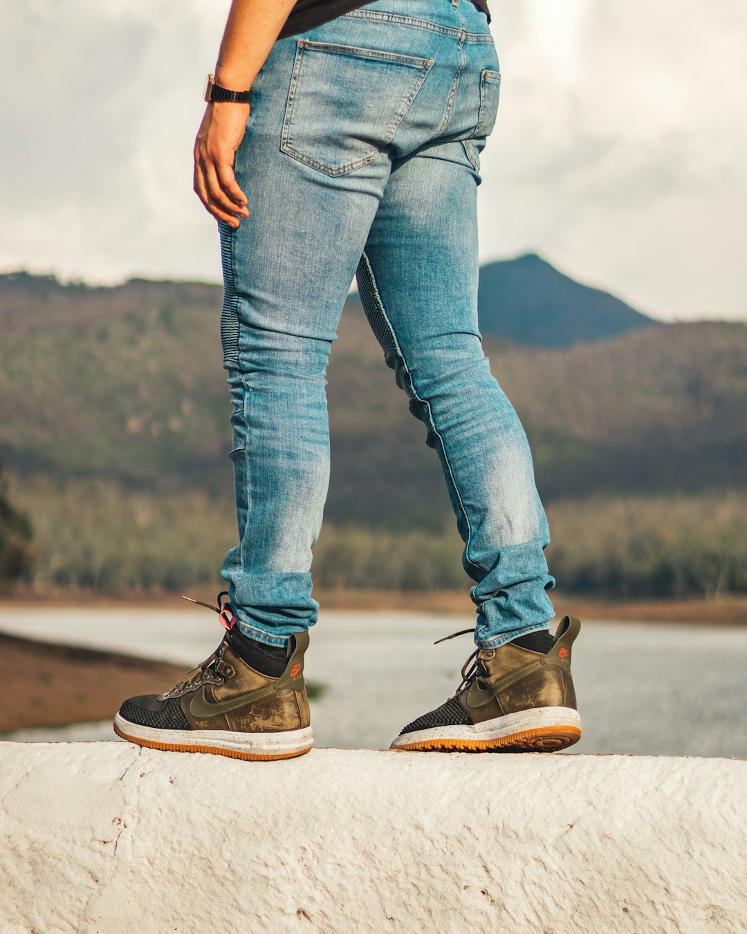 person in blue denim jeans and brown hiking shoes