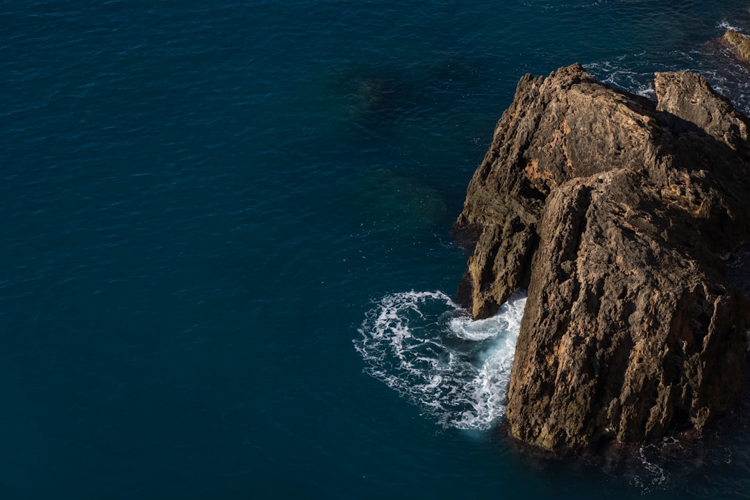 brown rock formation beside blue sea during daytime