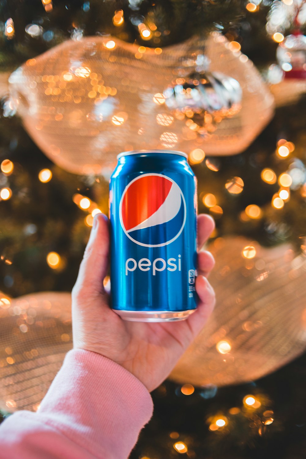 person holding pepsi can with water droplets