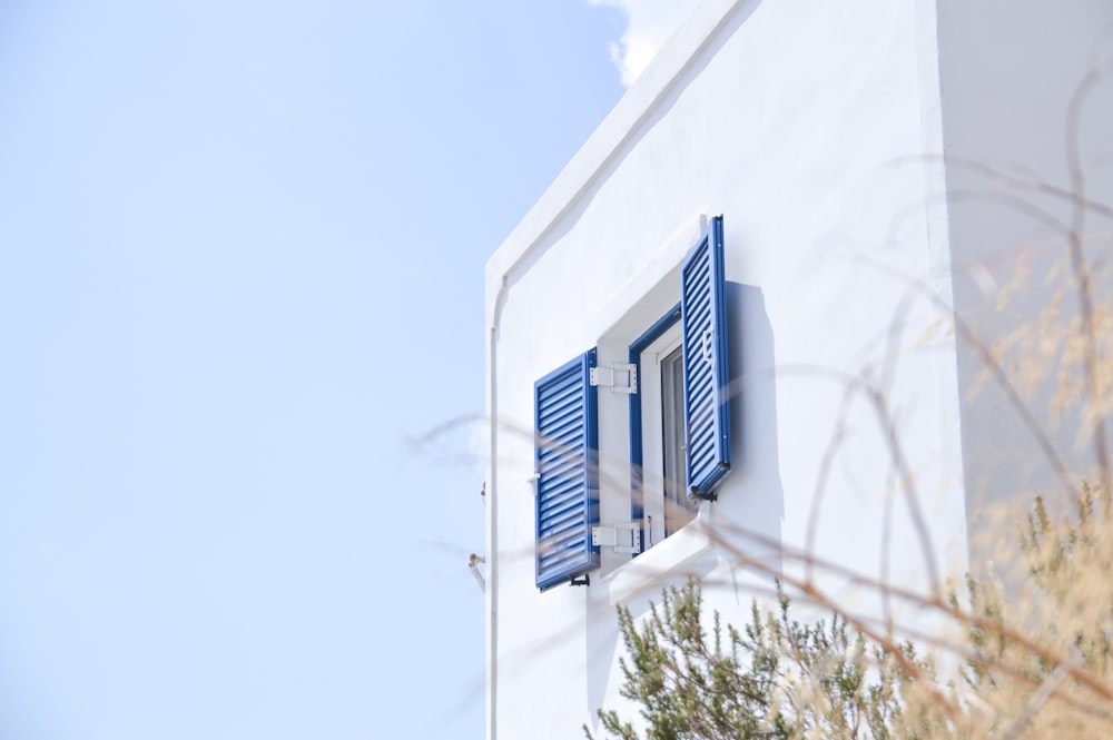 edifício de concreto branco com janela azul