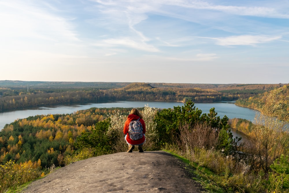 a person standing on a hill overlooking a lake