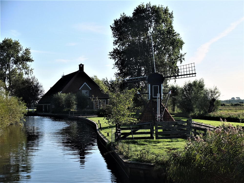 brown wooden house near river during daytime