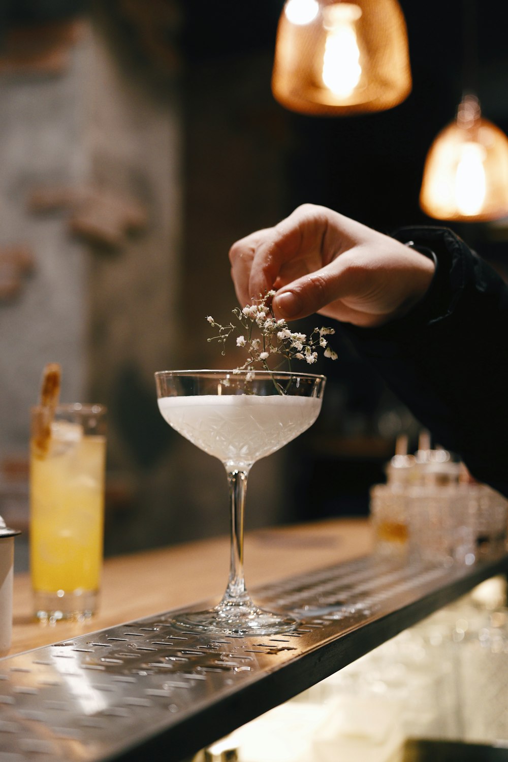 person holding clear wine glass with white liquid