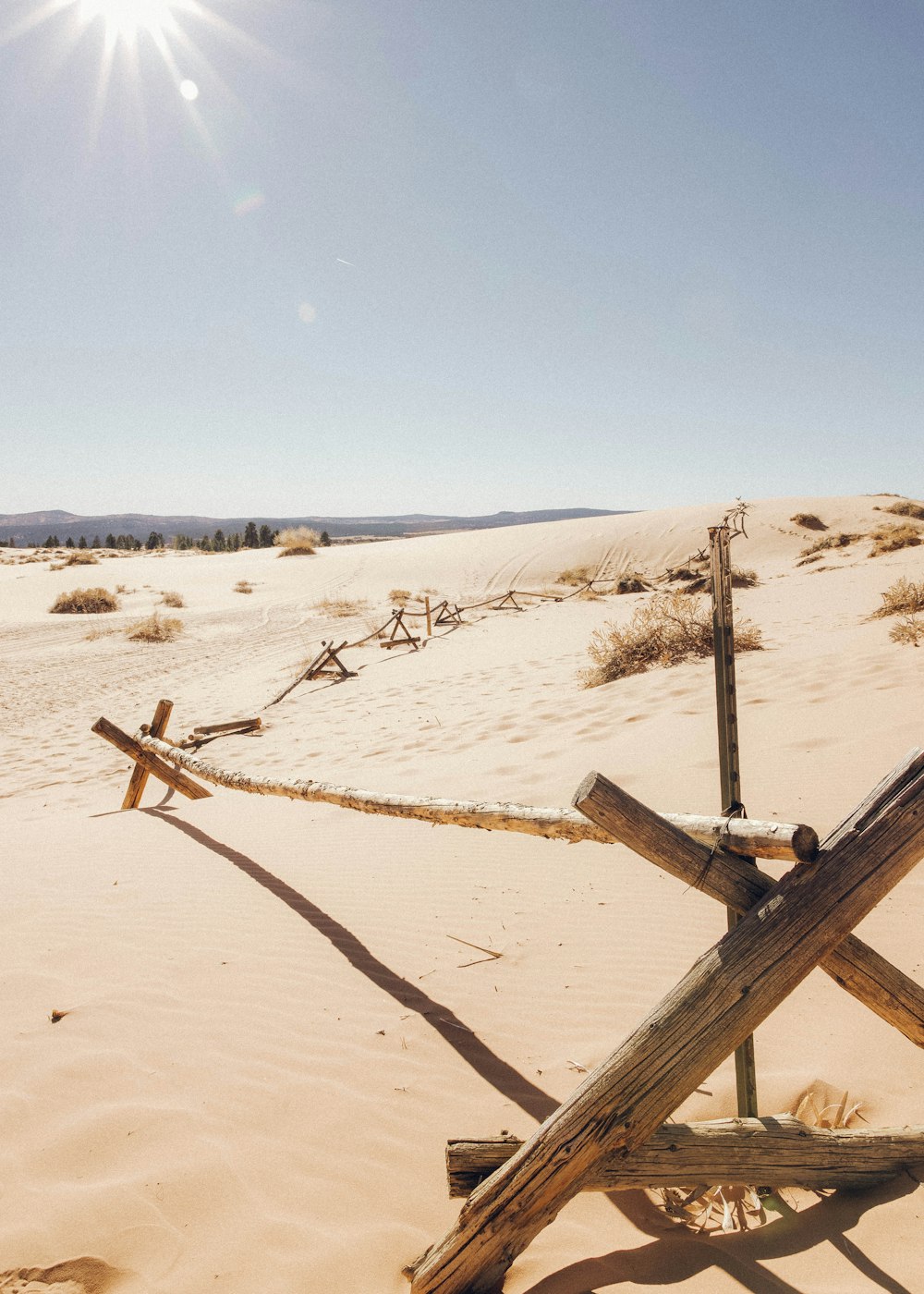 brown wooden fence on white sand during daytime