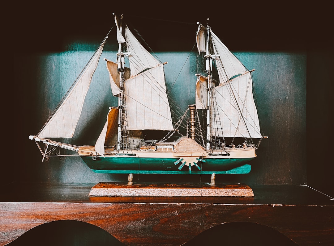 white and brown sail boat on body of water