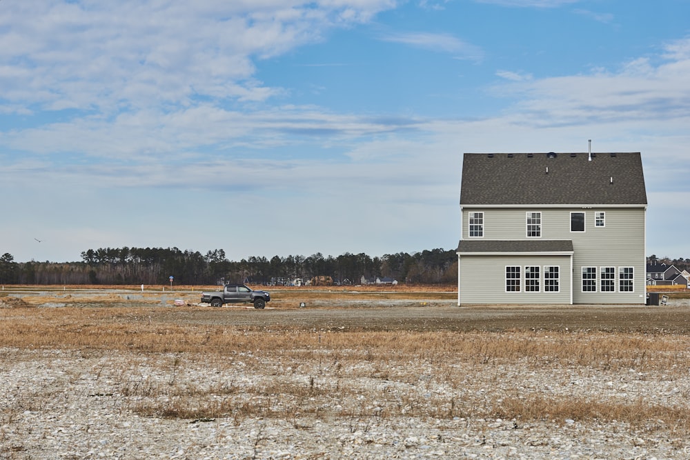 white and black house on brown field under blue sky during daytime